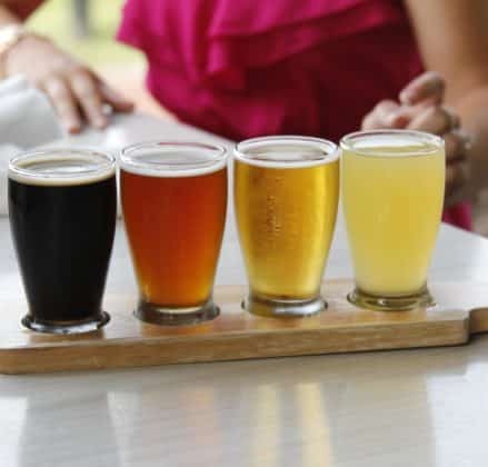 A flight of 4 beers, from very dark to amber to golden to pale.
