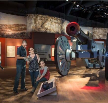 Family in a Revolutionary War museum with a big cannon behind them